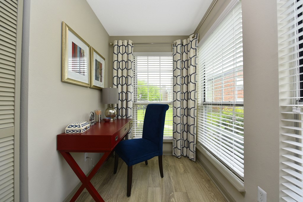 a home office with a red desk and blue chair in a 555 waverly unit