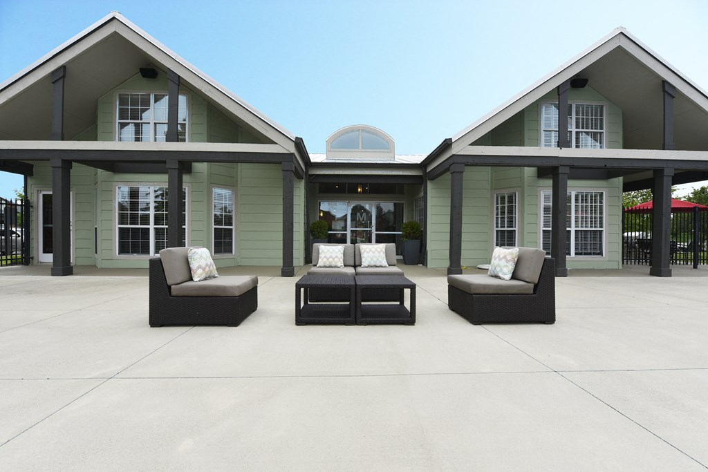 a large patio with furniture and a house in the background