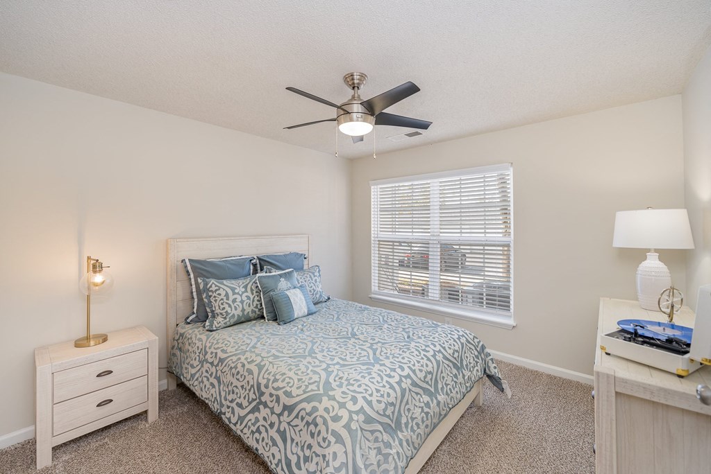 Reserve at Hamburg bedroom with a bed, a bedside table, carpeted floors, and a window.