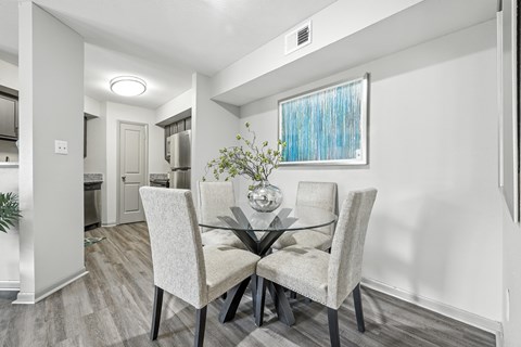 A dining room with a glass table and chairs.