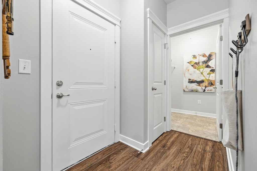 A hallway with a white door and a wooden floor.