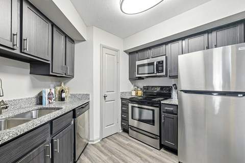 A kitchen with black cabinets and stainless steel appliances.