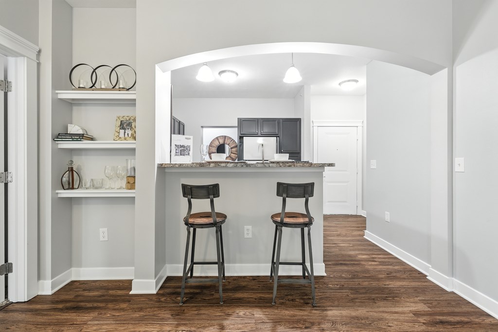 A kitchen with a bar area and two stools.