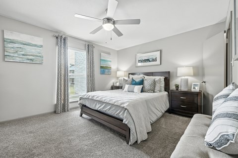 A bedroom with a large bed and a ceiling fan.