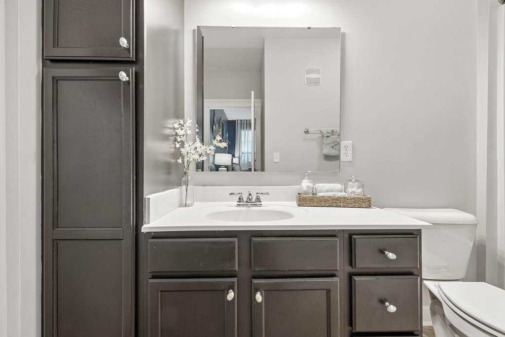 A bathroom with a white sink and a large mirror.