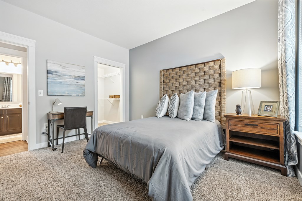 A bedroom with a large bed and a desk.