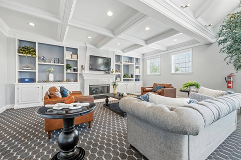 A living room with a grey couch and a black and white checkered floor.
