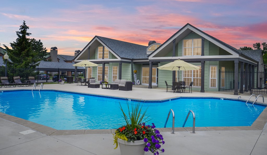Dog-Friendly Apartments in Fishers, IN - Metropolitan Fishers - Pool Surrounded By Lounge Seating with View of Apartment Buildings
