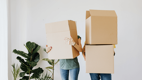 Two people holding cardboard boxes in front of their faces.