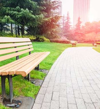 A park bench sits on a brick pathway.