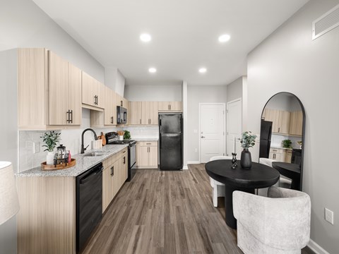A modern kitchen with wooden cabinets and a black refrigerator.