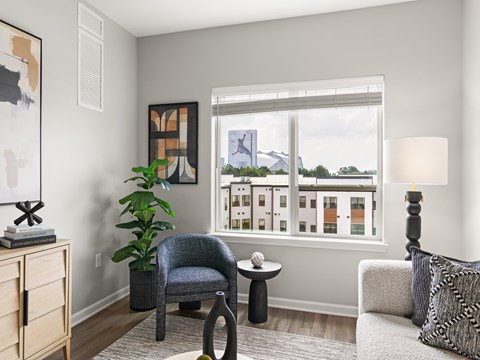A living room with a grey chair and a small table.