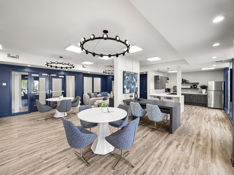 A modern dining area with a white table and grey chairs.