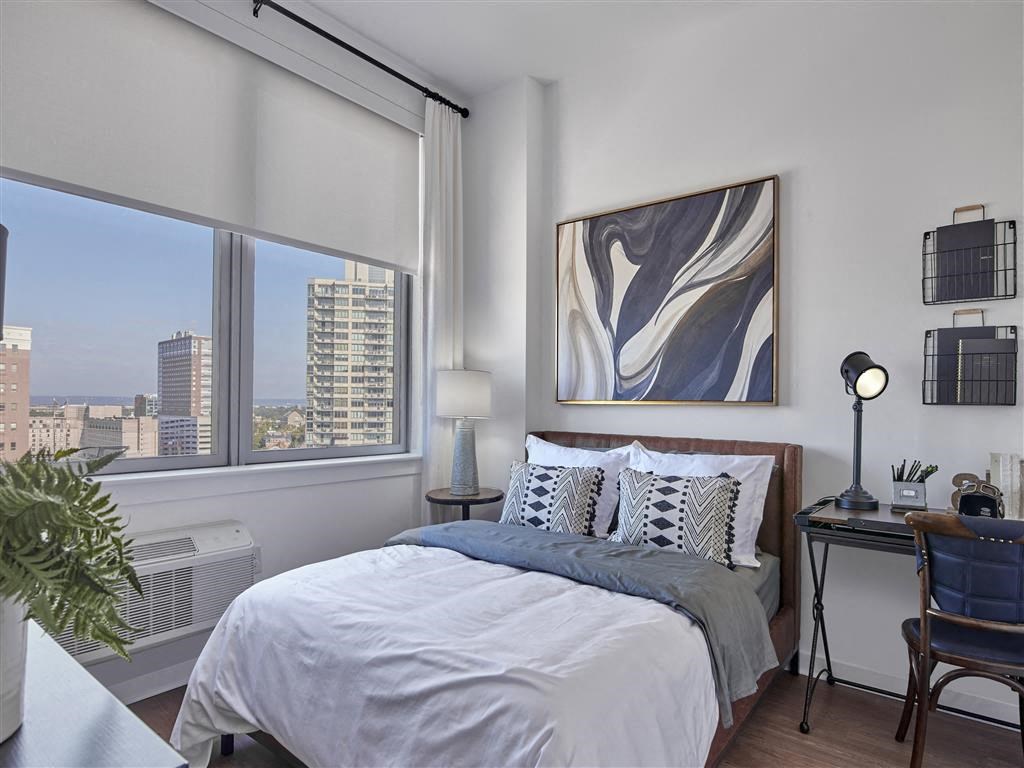 a bedroom with a bed and a large window