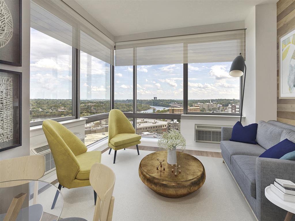 a living room with a view of the city and a couch and chairs