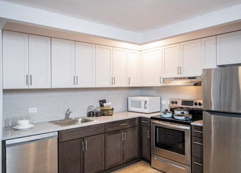 A kitchen with brown cabinets and stainless steel appliances.