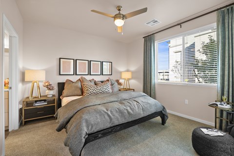 A bedroom with a large bed and a ceiling fan.