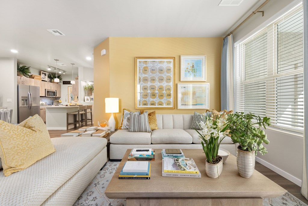 A living room with a grey sofa, a coffee table, and a yellow pillow.