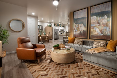 A living room with a brown leather chair and a grey couch.