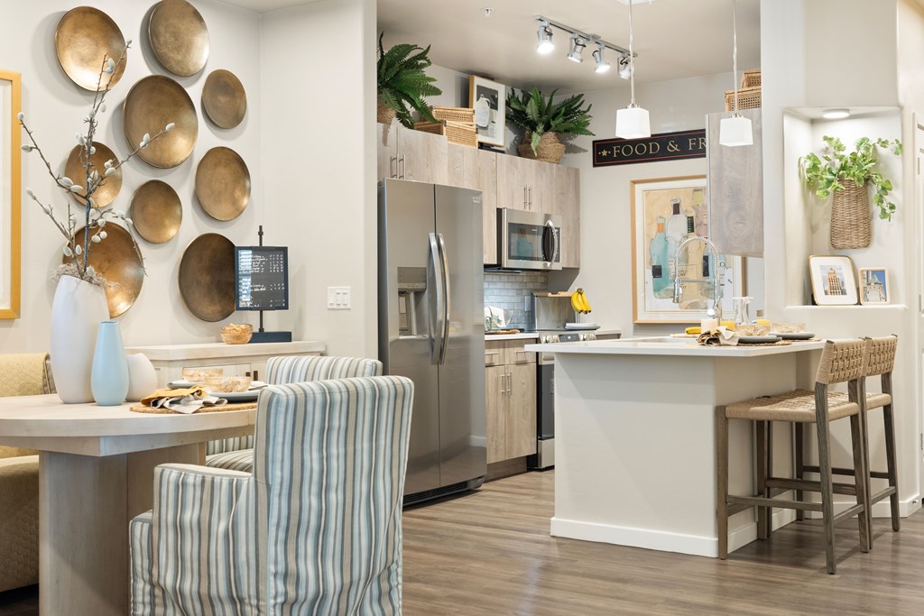 A kitchen with a bar area and striped chairs.