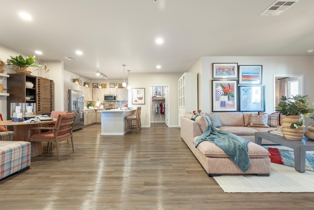 A spacious living room with a couch, chairs, and a dining table.
