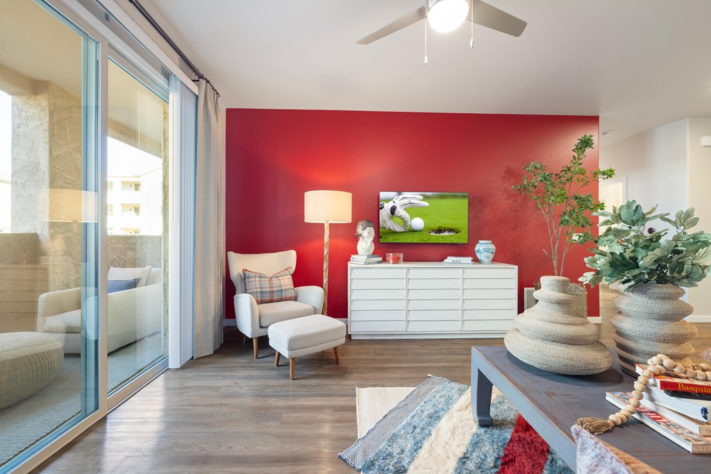 A living room with a red wall and a white cabinet.