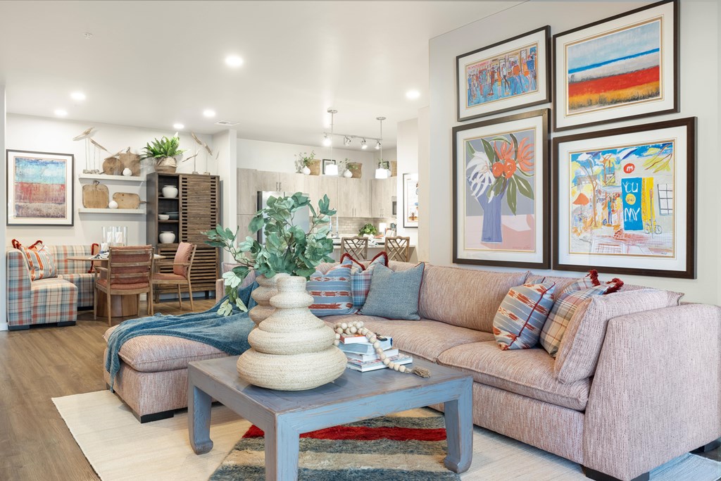 A living room with a couch, coffee table, and pictures on the wall.