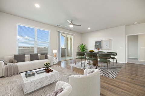 A modern living room with a white sofa, a coffee table, and a dining table set up.