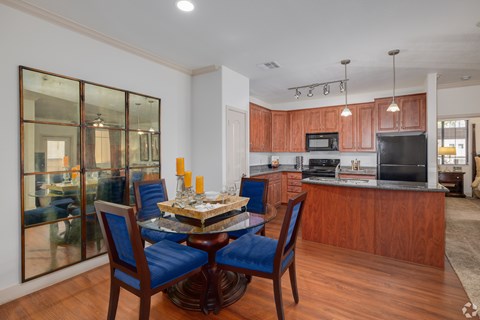 A modern kitchen with wooden cabinets and a glass dining table.