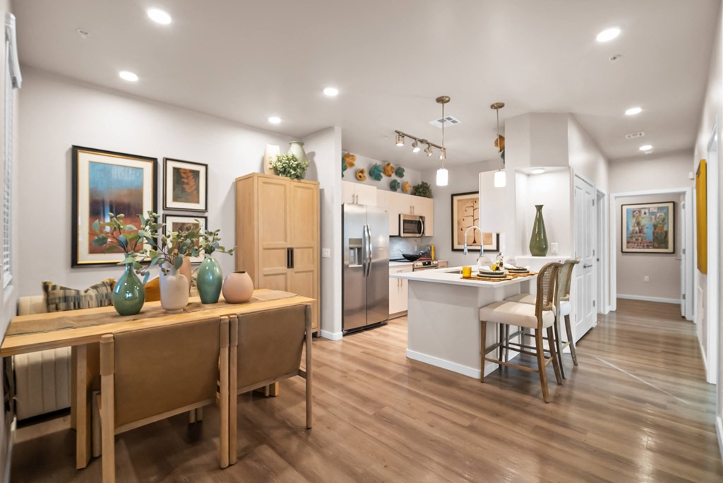 A kitchen with a dining table and chairs.