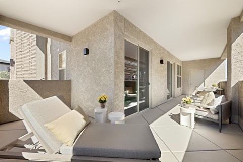 A modern living room with a white sofa and a grey cushion.