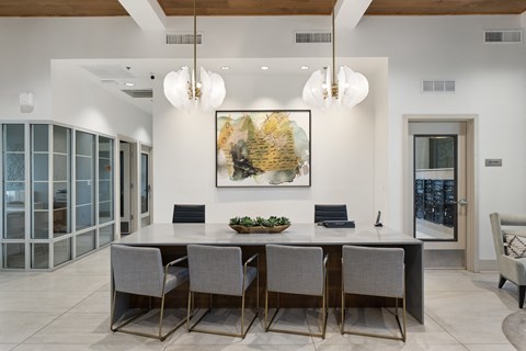 A dining room with a large table and chairs.