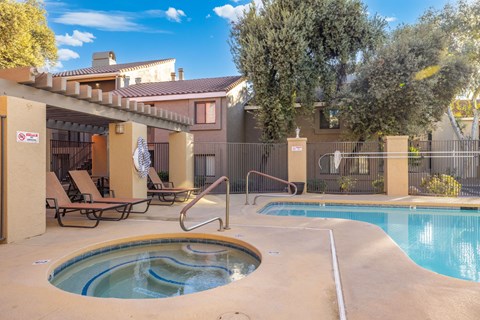 A pool with a slide and a hot tub.