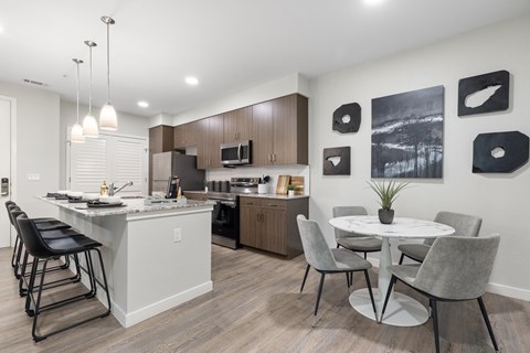 A modern kitchen with a dining table and chairs.