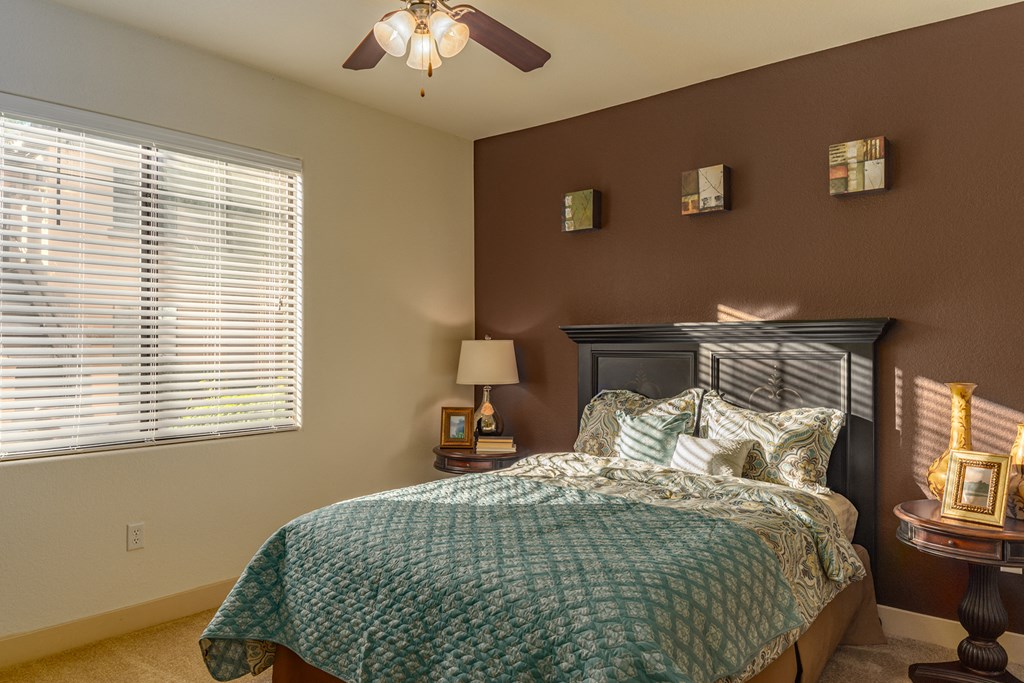 a bedroom with a bed and a ceiling fan