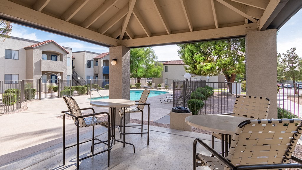 Seating under ramada with pool in background