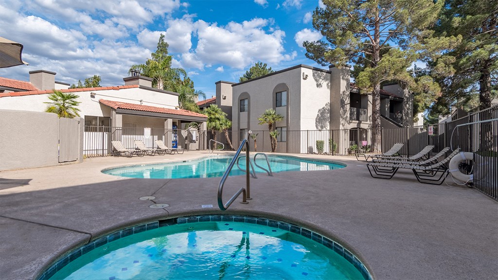 sunny pool area in front of apartment complex with shaded spa