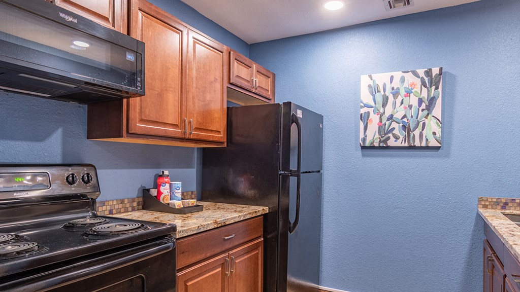canyon oaks clubhouse kitchen with plenty of cabinetry, a stove, and a fridge
