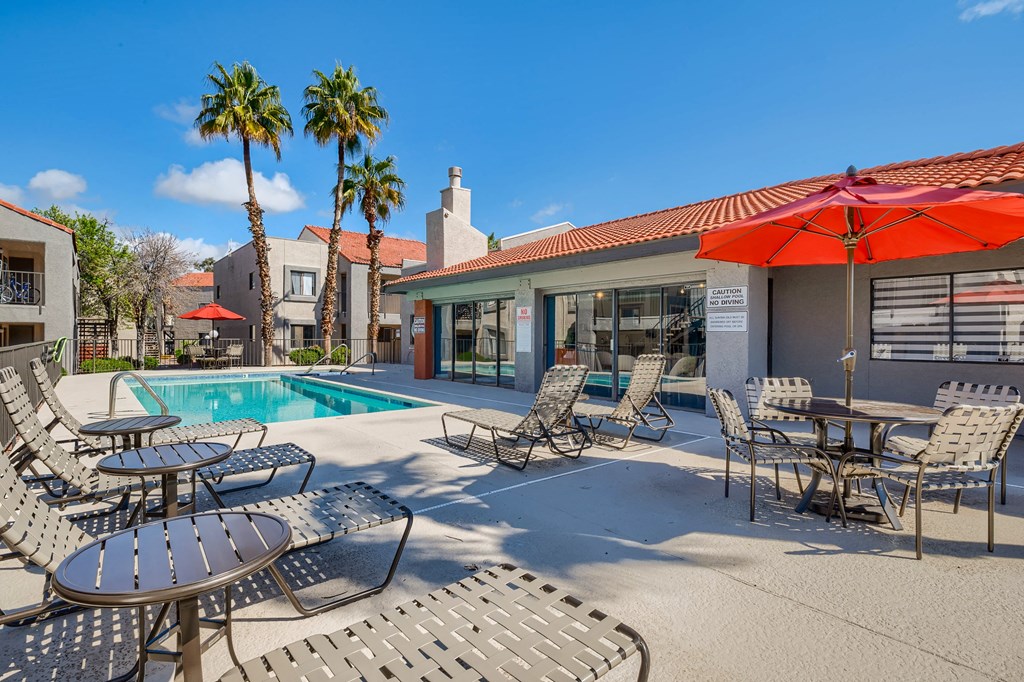 our apartments have a pool and patio with chairs and tables