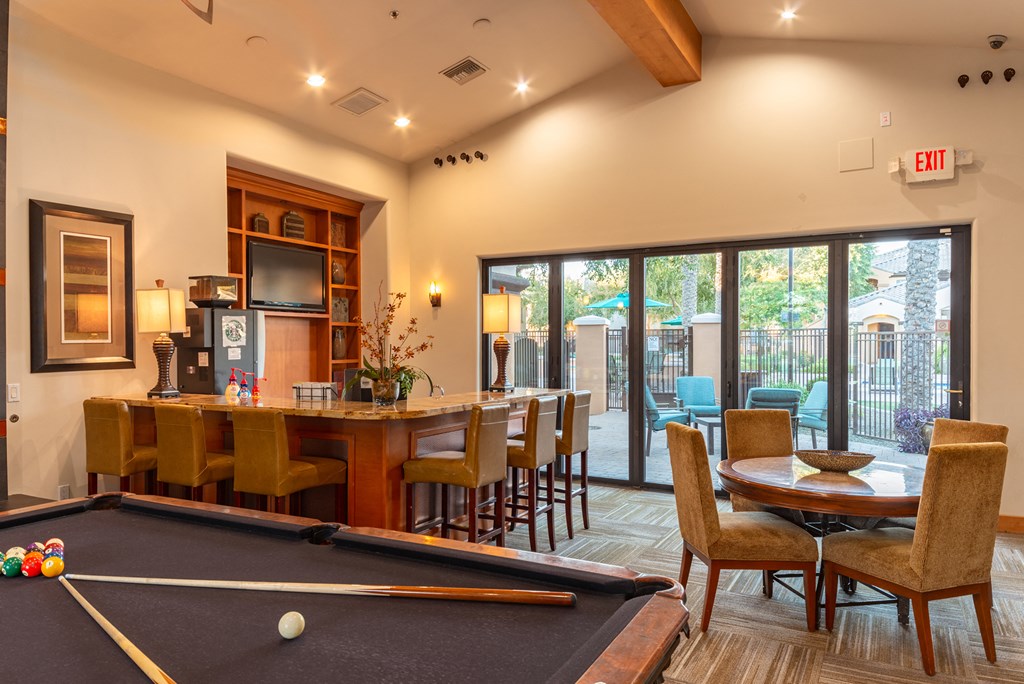 a game room with a pool table and a bar