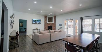 A living room with a couch, chairs, and a television.