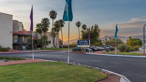 front entrance of apartment complex with sign and flags