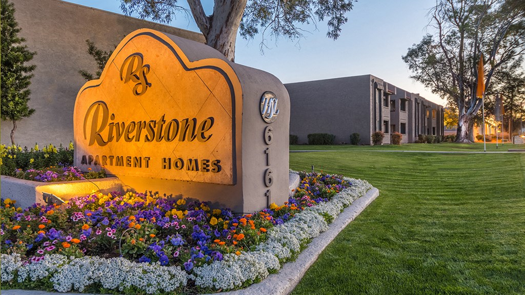 Riverstone community sign with lush landscape and flowers surrounding