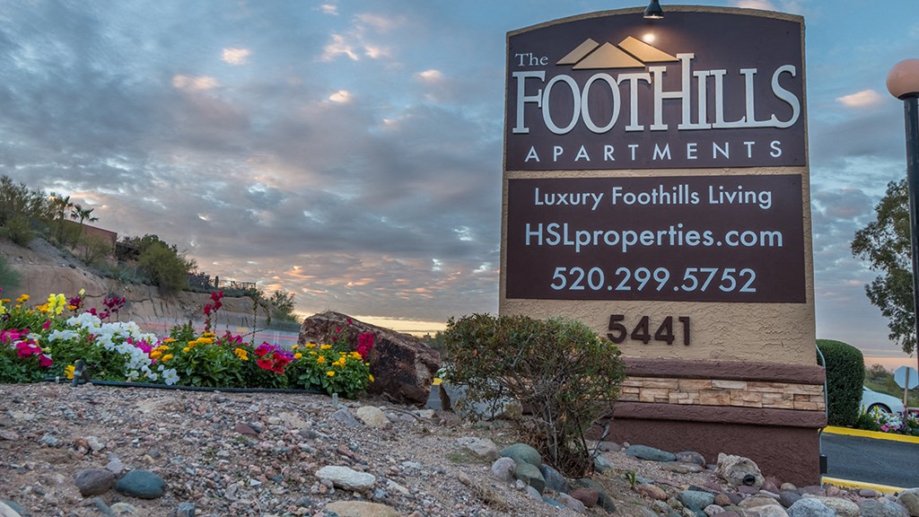 Foothills community sign with well kept entrance accompanied by colorful flowers