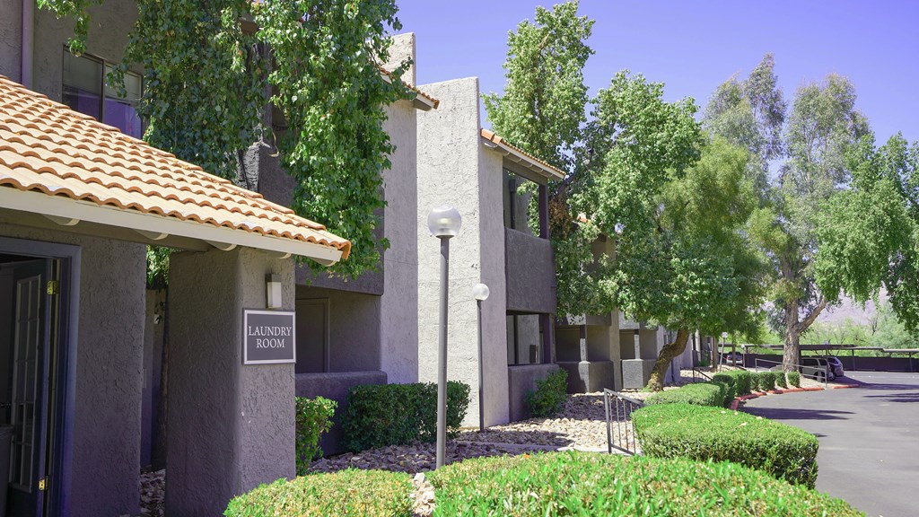 A laundry room sign is on a building in a quiet area.
