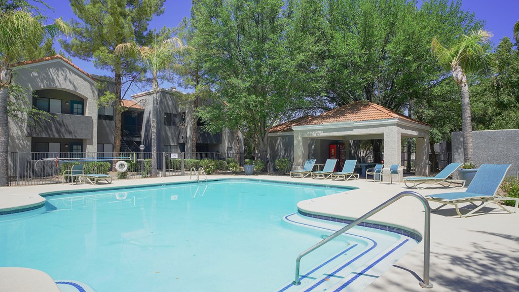 A pool with a slide and a gazebo in the background.