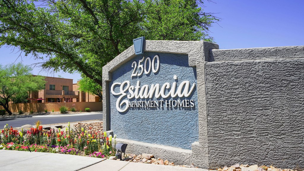 A sign for Estancia Apartment Homes is shown in front of a building.