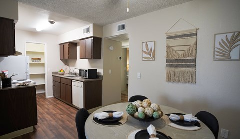 A kitchen with a table set for a meal.