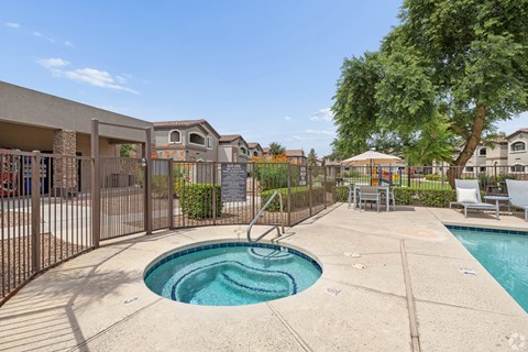 A small pool with a slide in the middle of a concrete patio.