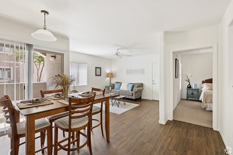 A dining room with a table set for six with a view of the outside.